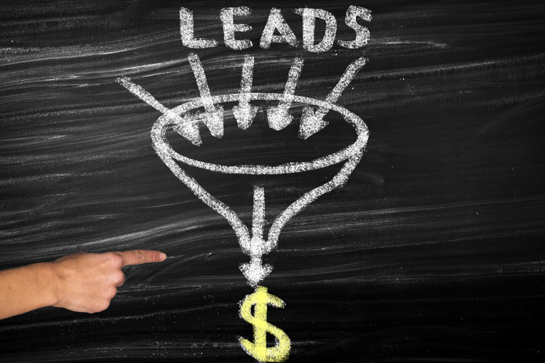 A finger points at a chalkboard with ‘leads’ written above a funnel and a dollar sign below.