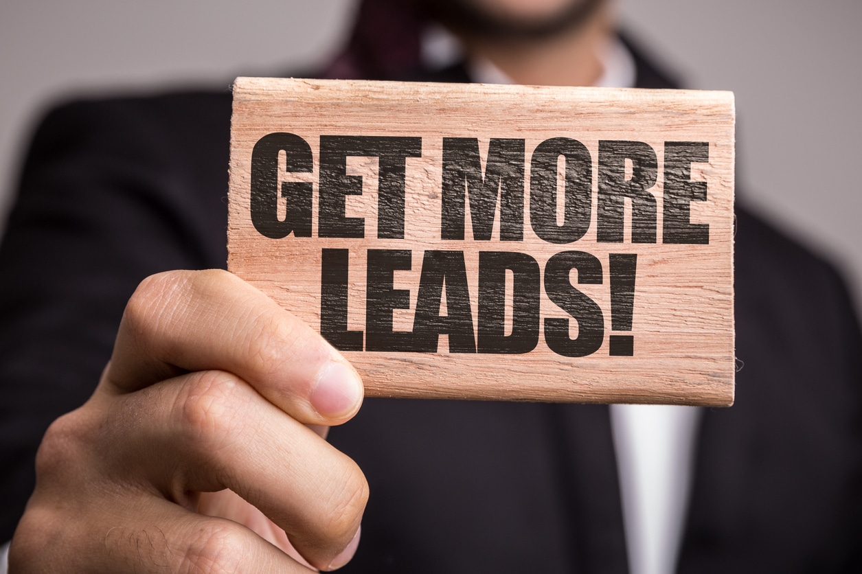 A man holds a sign that reads: Get more leads.